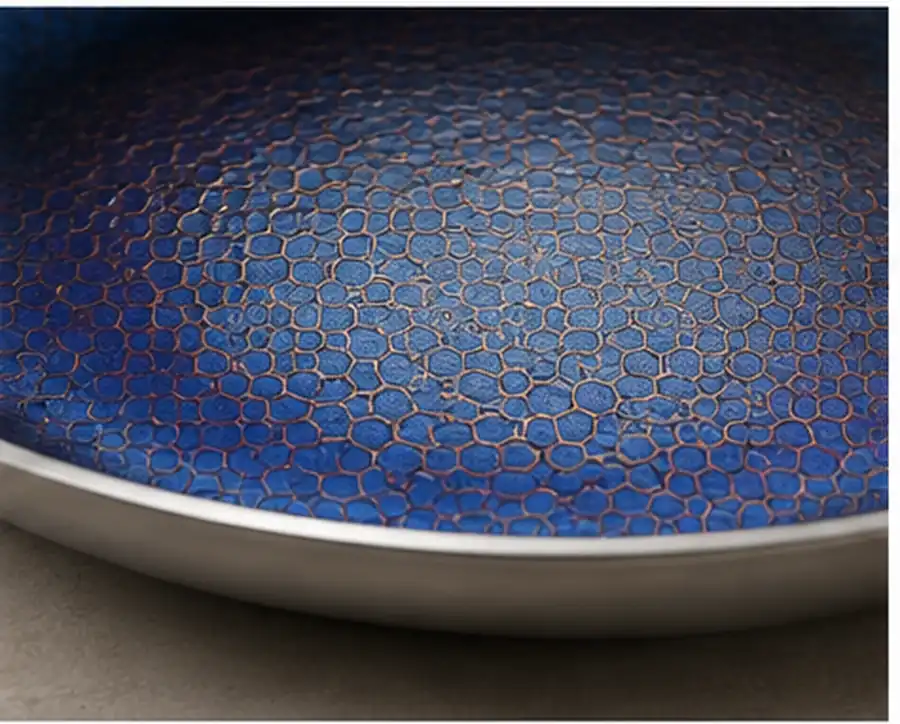 Blue titanium cookware surface showing natural titanium heat tint and surface texture