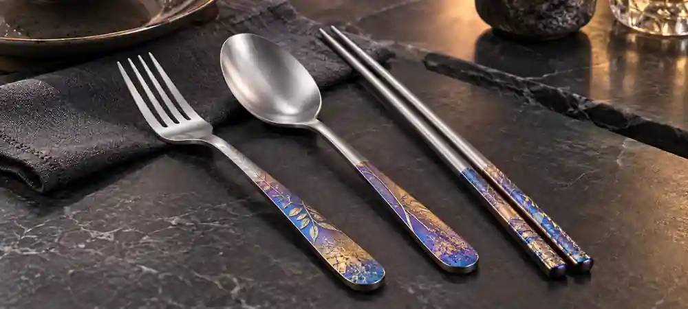 Anodized titanium cookware and tableware in a modern kitchen showing natural blue, gold and violet finishe